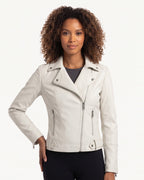 White moto jacket on model, asymmetrical zip front, snap collar, zip pocket accents.