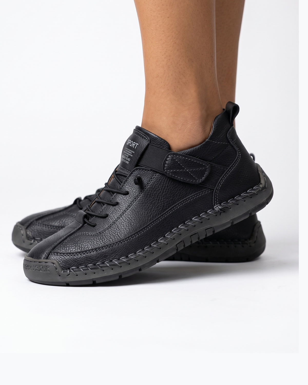 Black faux leather lace-up sneaker with ankle strap and textured rubber sole