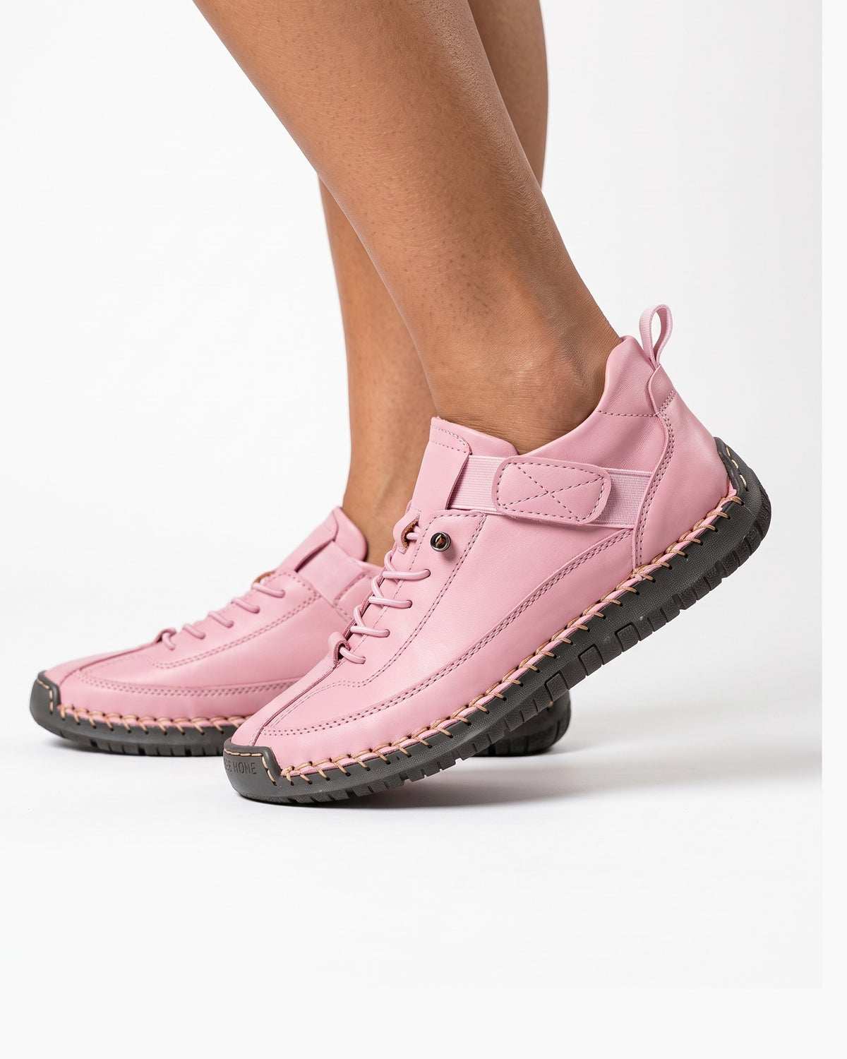 Pink faux leather lace-up sneaker with ankle strap and chunky textured sole