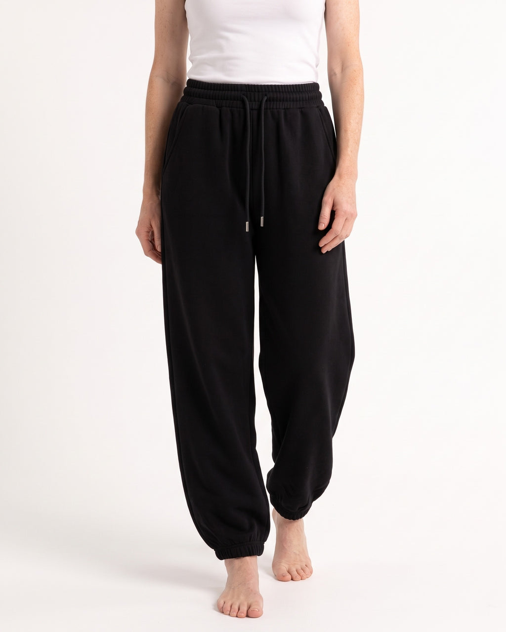 Black fleece jogger sweatpants, high waist drawstring, relaxed balloon legs, cuffed ankles