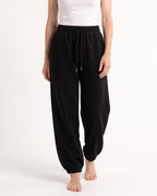 Black fleece jogger sweatpants, high waist drawstring, relaxed balloon legs, cuffed ankles