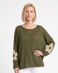 Women's olive green oversized knit sweater with beige flower motifs on the sleeves