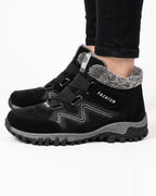 Women’s black fur-lined snow boots with hook-and-loop straps and rugged lug sole
