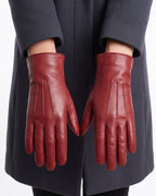 Women’s red leather gloves with stitched seams and fleece-lined wrist cuffs