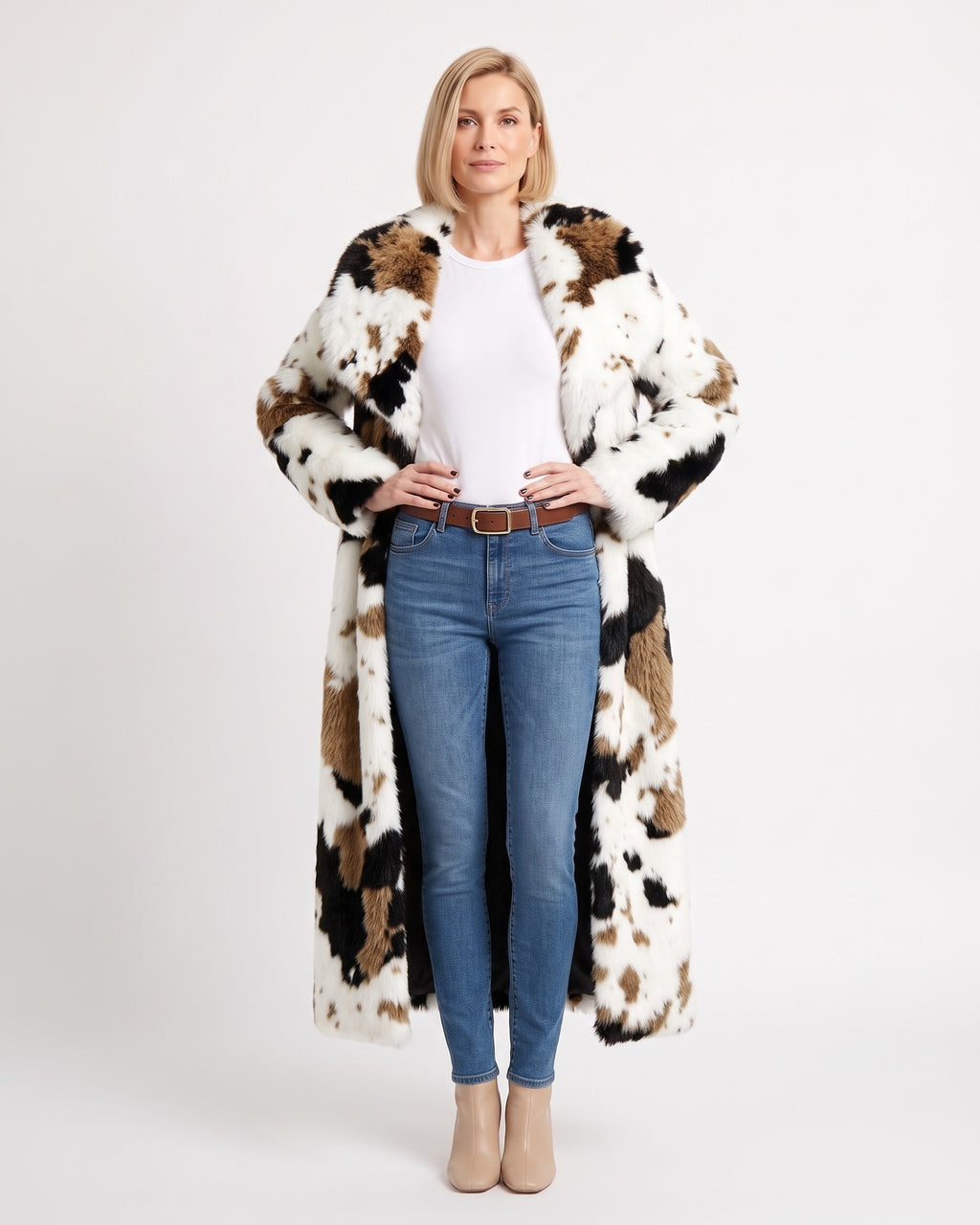 Long white faux fur coat with black and brown cow-print patches, worn open.