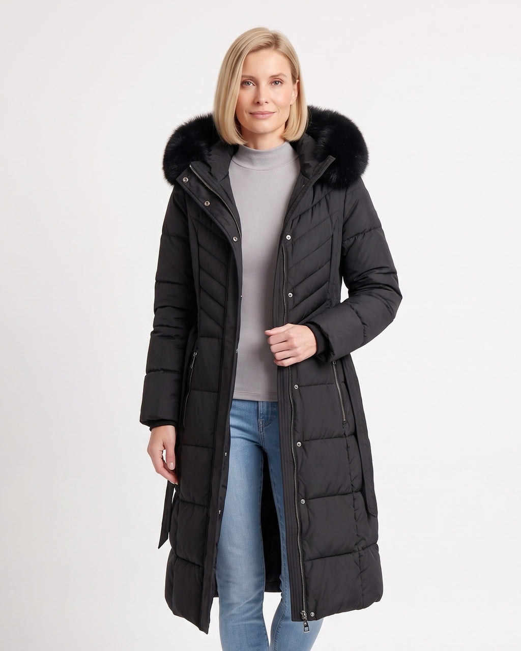 Women's long black puffer coat with faux fur trimmed hood, belt, and chevron quilting
