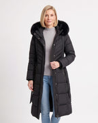 Women's long black puffer coat with faux fur trimmed hood, belt, and chevron quilting