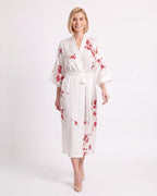 White satin kimono robe with red floral print, V-neck, wide sleeves, and tie belt.