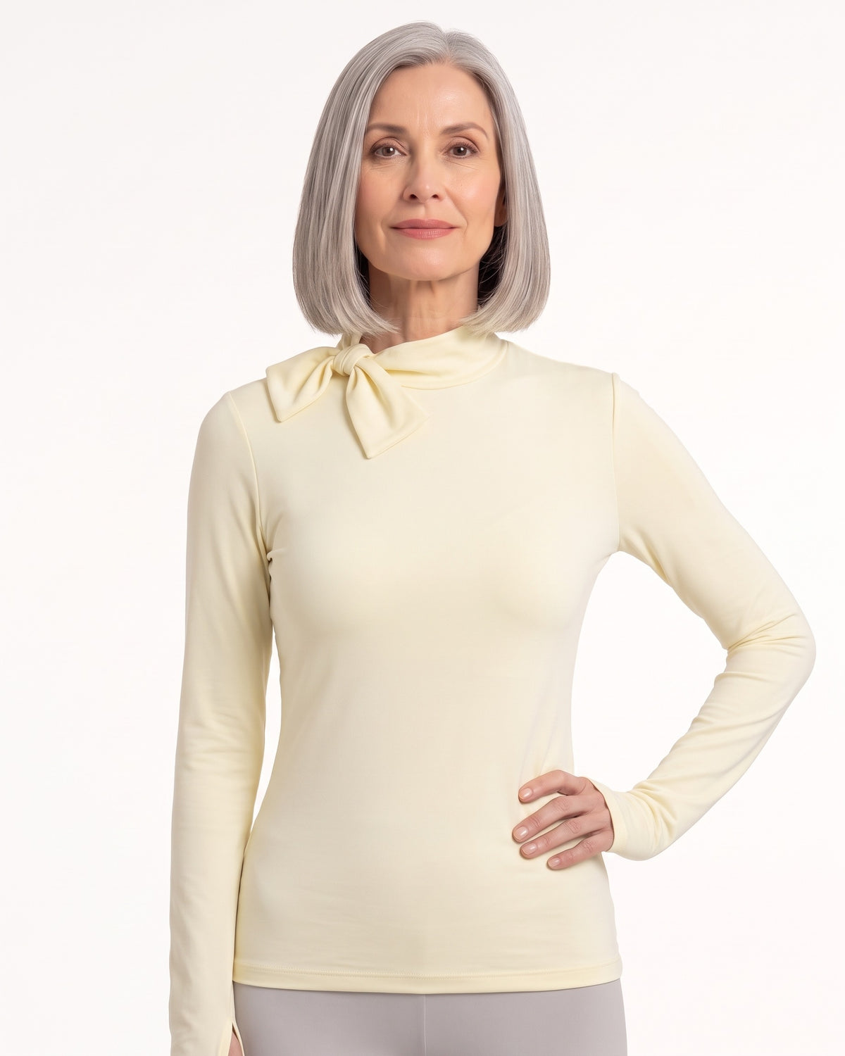 Light yellow long-sleeve mock neck top with bow tie collar and slim fit.
