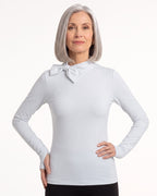 White long-sleeve mock neck top with bow tie collar and slim fit.