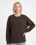 Brown crewneck knit sweater on model with ribbed cuffs and relaxed oversized shape