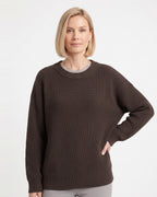 Brown crewneck knit sweater on model with ribbed cuffs and relaxed oversized shape