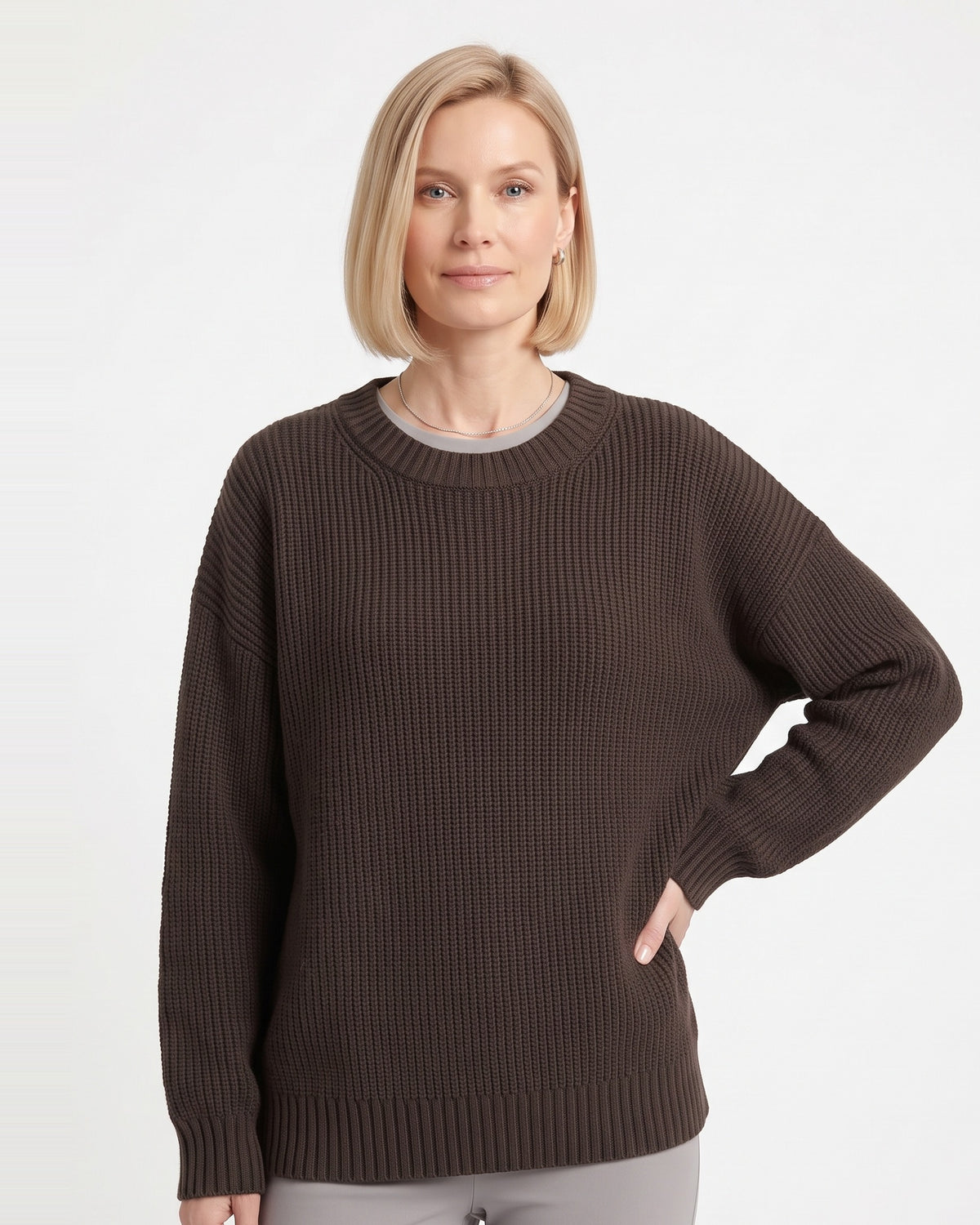 Brown crewneck knit sweater on model with ribbed cuffs and relaxed oversized shape