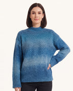 Women’s oversized mock neck gradient knit sweater in blue ombre with ribbed hem.