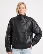 Black faux leather oversized jacket with stand collar, snap buttons, and zip front
