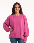 Women's oversized hot pink sweatshirt with batwing sleeves, exposed seams, and side slits