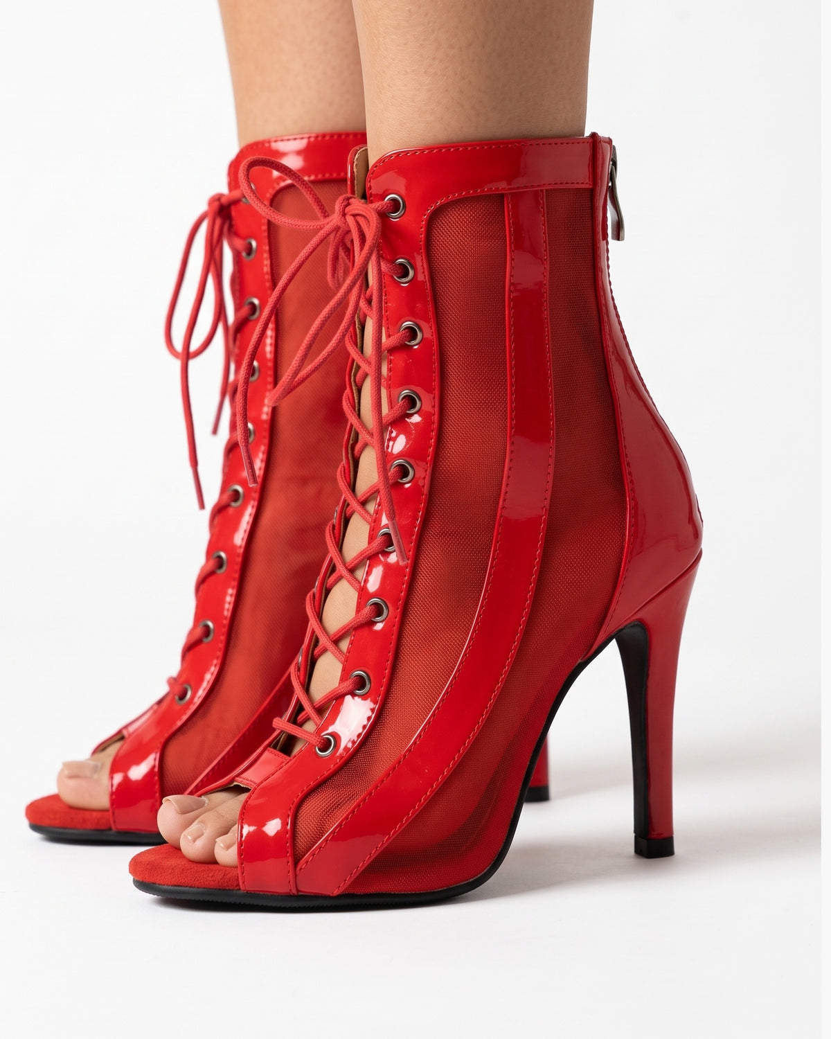 Red peep-toe lace-up stiletto ankle booties with sheer side panels and open toe.