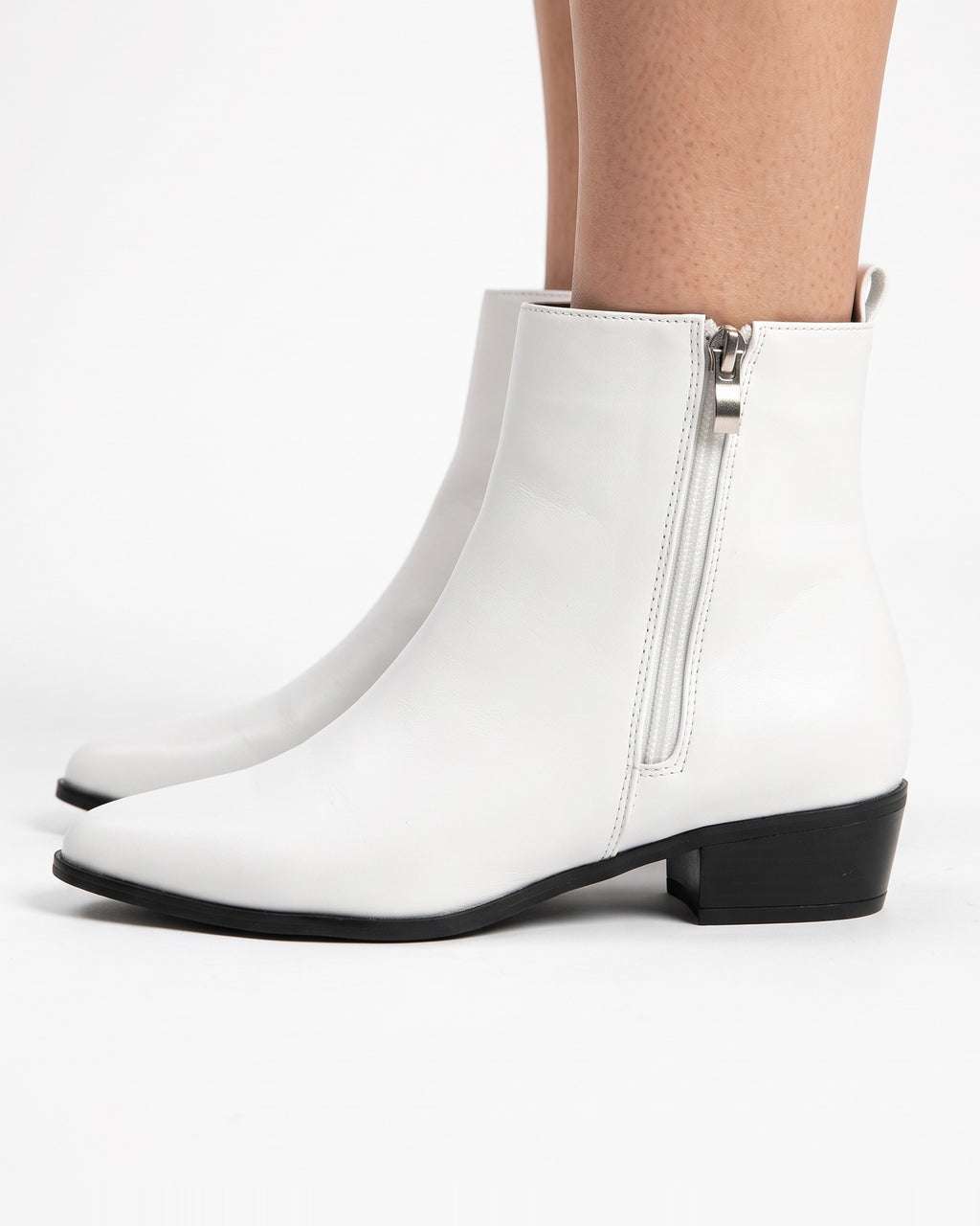 White pointed-toe ankle booties with side zipper, low block heel, smooth faux leather