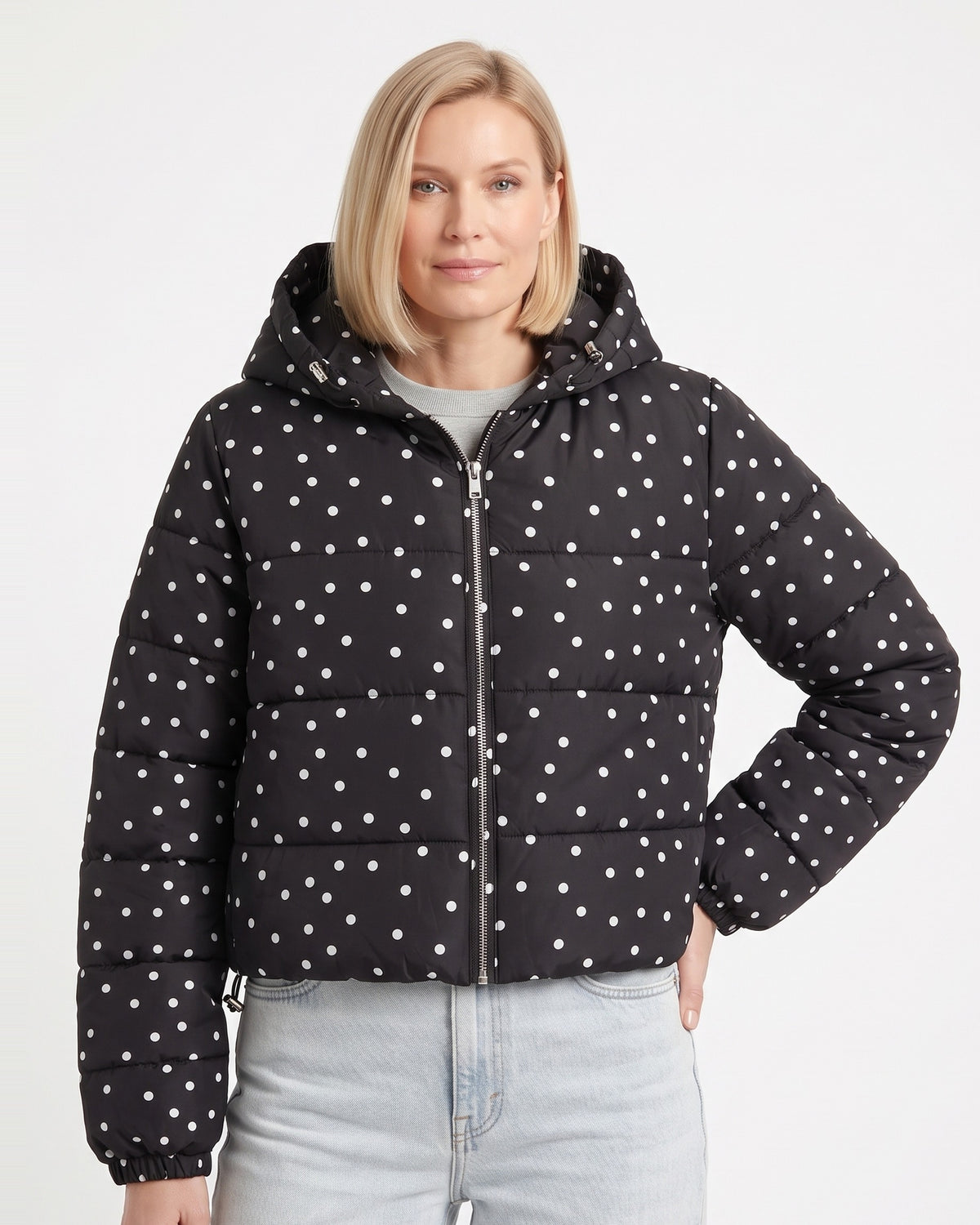Black polka dot cropped hooded puffer jacket on model, front zipper and hood.