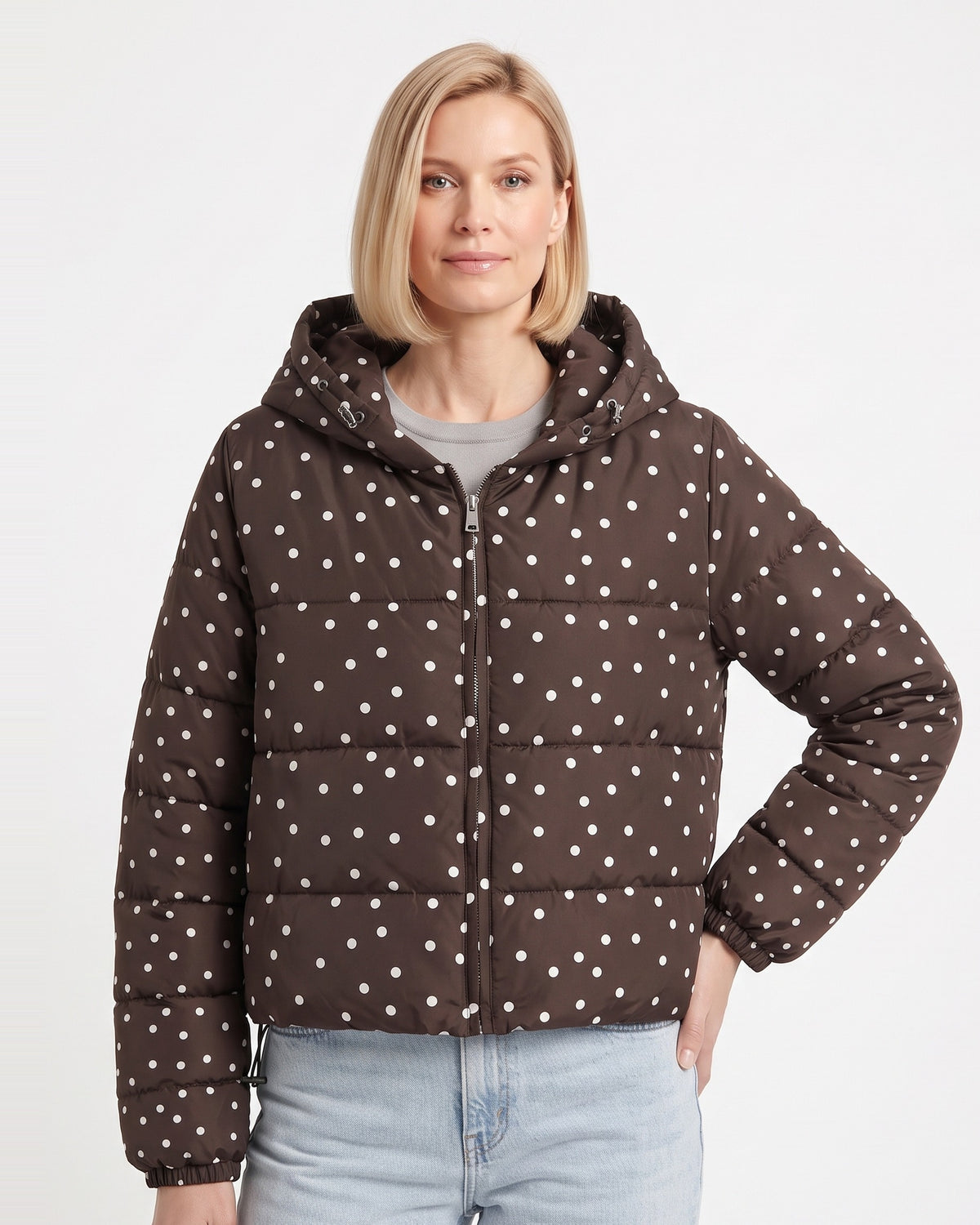 Brown polka dot cropped hooded puffer jacket on model, front zipper and hood.