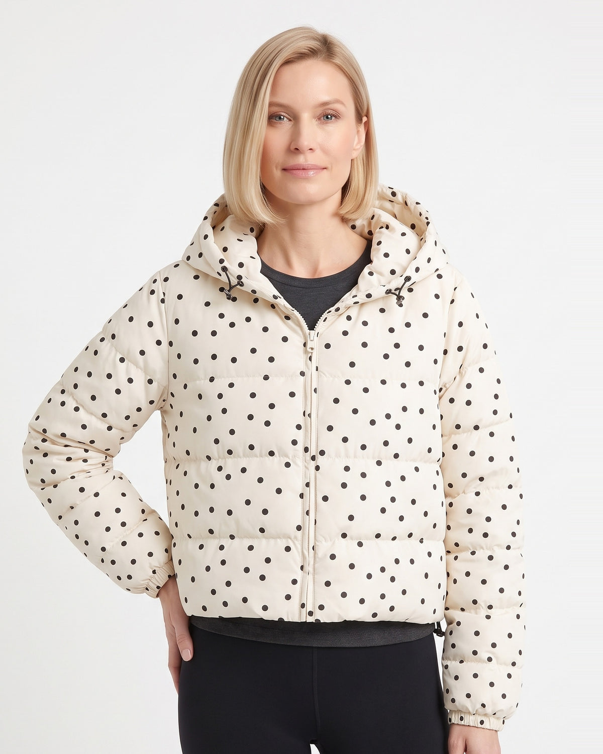 Cream polka dot cropped hooded puffer jacket on model, front zipper and hood.