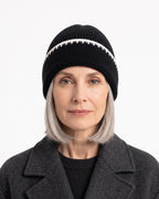 Black ribbed knit beanie with white contrast stitch trim and folded cuff