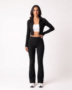 Black ribbed knit lounge set with cropped zip jacket and high-waist flare pants.