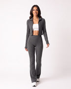 Dark gray ribbed knit lounge set with cropped zip jacket and high-waist flare pants.