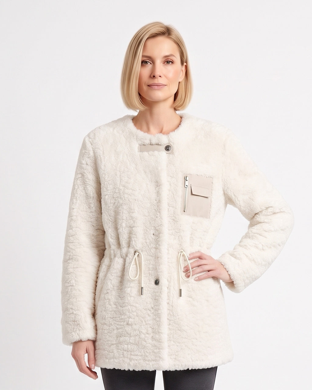 Model wearing an off-white sherpa jacket with drawstring waist and zip chest pocket.
