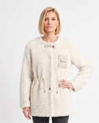 Model wearing an off-white sherpa jacket with drawstring waist and zip chest pocket.
