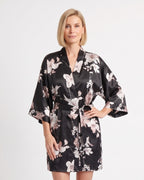 Short black satin robe with pale floral print, wide sleeves, and tie belt