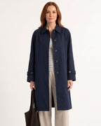 Navy mid-length trench coat with point collar, button front, and epaulet accents