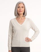 Women’s off-white V-neck fine-knit sweater with long sleeves, worn with dark pants