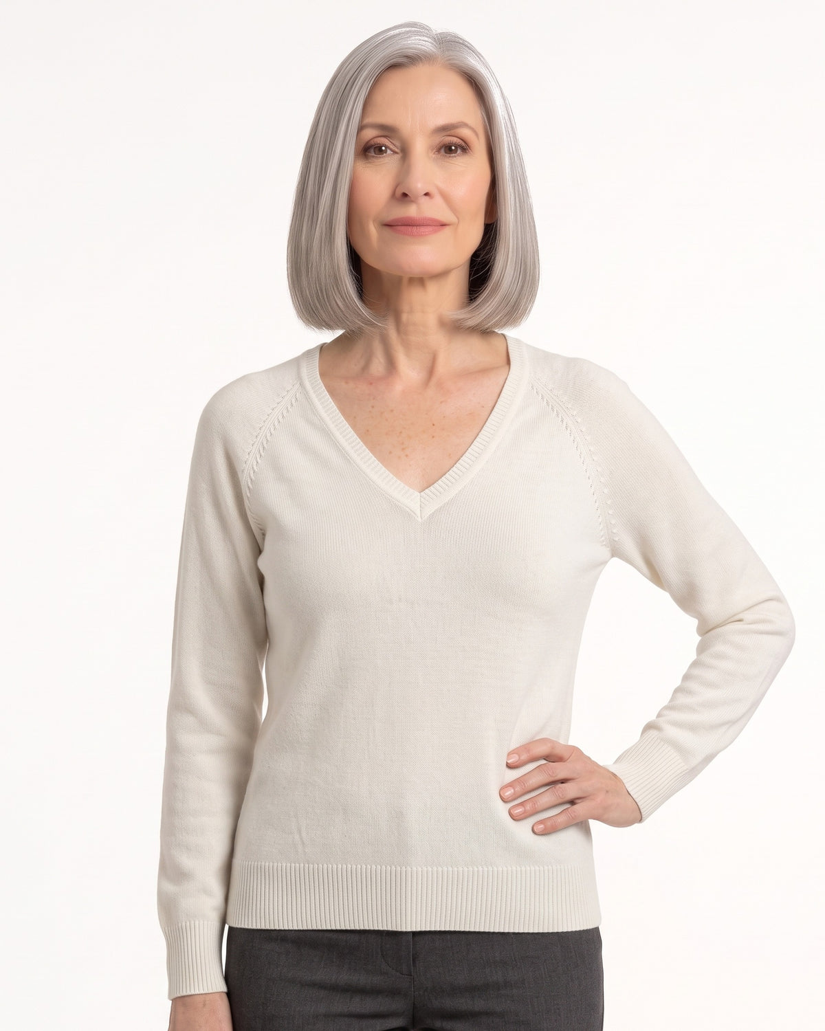 Women’s off-white V-neck fine-knit sweater with long sleeves, worn with dark pants