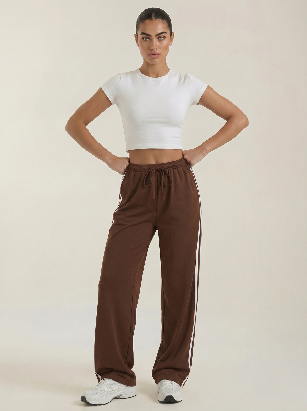 Brown wide-leg track pants with elastic drawstring waist and white side stripes.
