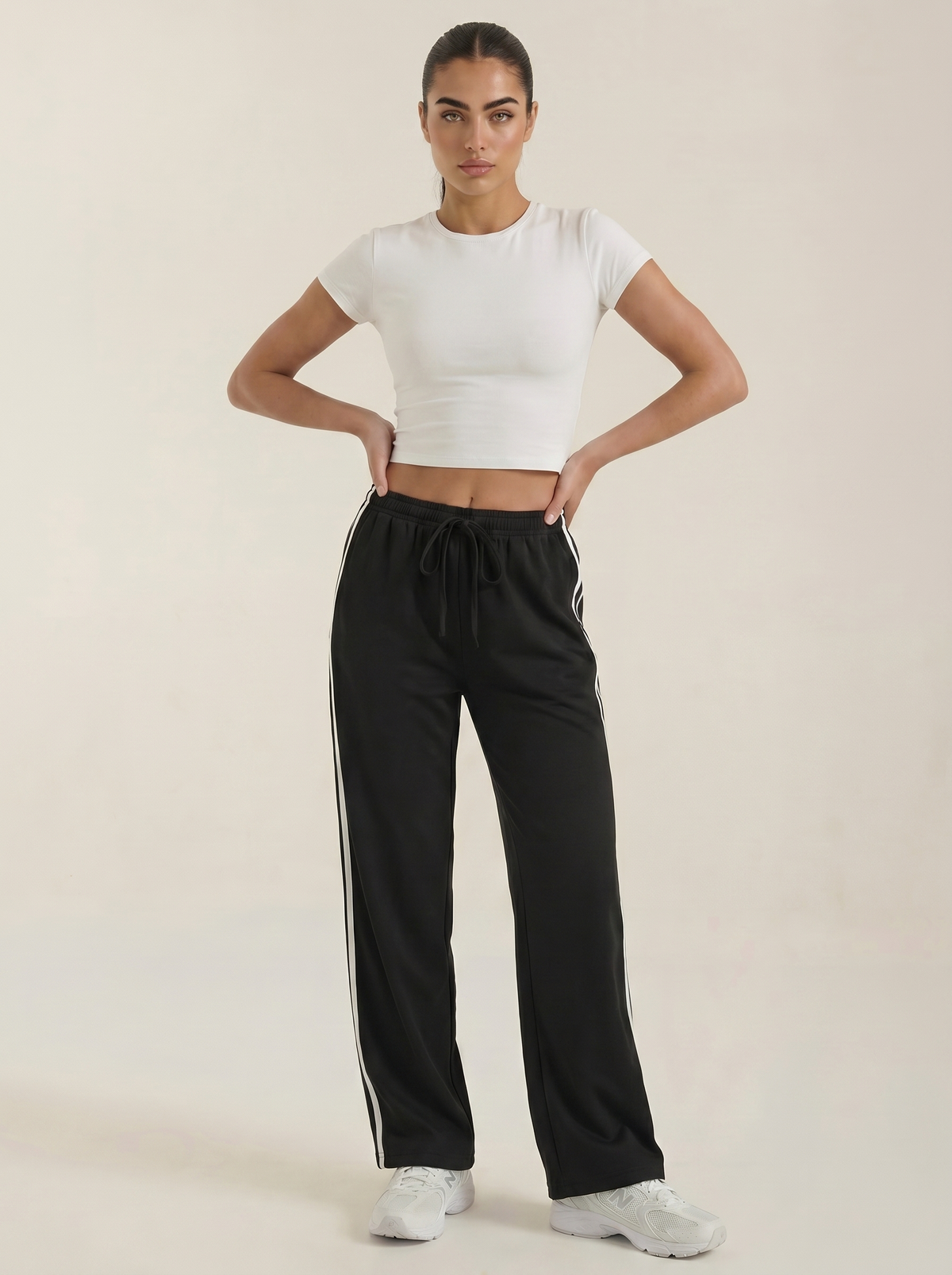 Black wide-leg track pants with elastic drawstring waist and white side stripes.